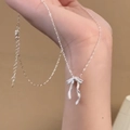 French style silver matte 3D bow necklace with delicate ribbon chain on model - Melon Seed Chain