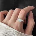 Macro d'une bague sirène en argent avec une pierre d'opale ovale aux reflets irisés - Incrustation d'opale / Argent (Bague Océan)