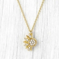 Dettaglio macro della collana con ciondolo a sole e zirconi su sfondo di legno rustico - Collana Sole Dorato