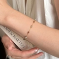 Bracelet chaîne en or minimaliste avec perles de pierre colorées sur poignet de femme - Bracelet