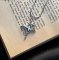 Detailopname van een zilveren sterhanger aan een ketting op een open boek achtergrond - Grote en Kleine Sterren - Slangenketting