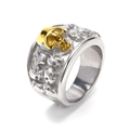 Detail of vintage skull ring featuring silver relief skulls and central golden skull accent - US 7 / Two-Tone Gold
