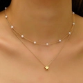 Detail of double-layered gold necklace featuring pearls and a star pendant on a model - Gold Double-Layer Pearl Star Necklace (XL1080-3)