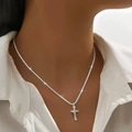 Glinsterende zilveren kruisketting met pavé-kristallen gedragen door een model - Stijl 2457 Enkele Ring