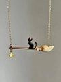 Detalle de un collar vintage con un gato de esmalte negro sentado en una escoba dorada - Dorado