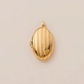 Gedetailleerd zicht op een ovale gouden medaillon met verticale strepen en scharnier - Gouden ovale hanger