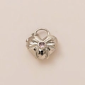 Macro-weergave van zilveren hartvormig medaillon met strik en roze edelsteen - Stalen Hart Hanger