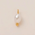 Detailed macro view of an oval white pearl pendant with 18K gold plated bead and metal loop - Pearl Pendant