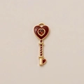 Detailed view of vintage heart key pendant with red enamel and gold-plated finish - Red Key Pendant