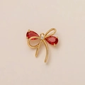 Elegant gold bow pendant featuring two pear-cut red stones and central zircon - Red Bow Pendant