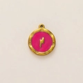 Detalle macro del colgante redondo dorado con esmalte rosa y símbolo de rayo en relieve - Rayo Rosa