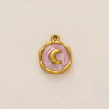 Detalle de un colgante redondo chapado en oro 18K con media luna sobre resina jaspeada rosa - Luna