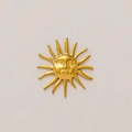 Close-up of 18K gold sun pendant with relief face detail and polished rays texture - Sun