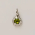 Macro shot of a silver pendant with a round green zircon in a vintage filigree setting - August Birthstone