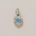Macro detail of silver organic textured pendant with round blue gemstone setting - December Birthstone