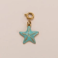 Macro view of a gold-plated starfish pendant with light blue enamel and textured gold dots - Starfish Pendant