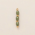 Détail macro de perles vert olive avec pendentif de fruit en acier plaqué or 18k - Pendentif à perles