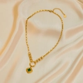 Detail of gold titanium steel necklace featuring a square green gemstone on satin - Emerald Necklace