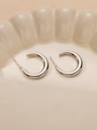 Dettaglio di orecchini a cerchio a forma di C in argento su vassoio in porcellana - Stile Lucido a Mezzaluna Minimalista (#0214)