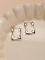 Close-up of silver titanium steel rectangular hoop earrings in a ceramic dish - Geometric Rectangular Style (#0213)