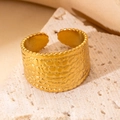 Detailansicht eines goldenen breiten Rings mit Kieseltextur auf beigem Stein - Vintage Unregelmäßig Strukturierter Stil (BJGR0270)