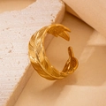 Detailaufnahme eines goldenen Federrings mit Vintage-Gravur auf einer Steinfläche - Federtextur Gravierter Offener Stil (BJGR0273)
