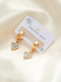 Dettaglio macro degli orecchini a cuore in acciaio dorato con strass bianchi scintillanti - Gemma con strass incastonati