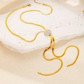 Elegante goldene Schlangenkette mit funkelndem Herzanhänger auf einem stilvollen Steinuntergrund - Kristall Pavé Herz Halskette