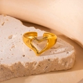 Detailansicht eines hohlen herzförmigen Goldrings auf einer strukturierten Natursteinfläche - Gold Hohlherz Geometrischer Ring (BJGR0280)