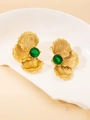 Detailed macro shot of vintage gold leaf earrings with round green gemstones in a white tray - Green Petal Stud Earrings