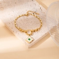 Golden titanium steel bracelet with green emerald square pendant and diamond halo detail - Crystal Square Bracelet