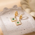 Close-up of vintage gold earrings with green gems and white enamel in a ceramic bowl - Crystal Square Earrings