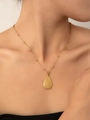 Dettaglio di una collana con ciondolo a goccia dorata con finitura testurizzata e catenina - Catena a Goccia d'Acqua (Placcato Oro)