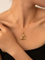 Dettaglio della collana in titanio dorato con ciondolo a cuore floreale e perle sul modello - Catena a Cuore con Perla (Placcato Oro)