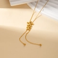 Collier élégant en titane doré avec pendentifs fleurs superposés et détails de perles - Fleur