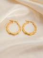 Detailed close-up of gold bamboo textured titanium steel hoop earrings on silk background - Bamboo E0253 Style