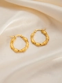 Macro shot of gold-plated titanium earrings with elegant twisted texture on silk cloth - Round E0256 Style