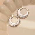 Detailed macro view of silver half-moon hoop earrings with spiral wave texture on ceramic - Spiral Crescent Wavy Style (BJGE0237) / Silver