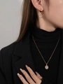 Nahaufnahme eines eleganten Goldschmucksets aus Titanstahl mit Zirkonia-Anhängern - Klares Set
