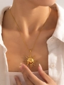 Close-up of gold sun pendant necklace with Greek totem design on white linen - Grecian Sun Ray Style