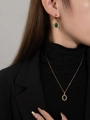 Modell trägt Goldschmuckset mit ovalem grünem Zirkon und Diamant-Heiligenschein - Set mit grünen Zirkonia