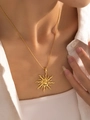 Detailed view of a gold sun pendant necklace with wave rays on a model skin - Sun Necklace