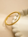 Close-up of gold titanium bangle with spiral texture on a white ceramic plate - Gold Spiral Textured Style