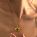 Elegante gouden titanium stalen ketting met groene edelsteen hanger gedragen door een model - Ronde Groene Edelsteen Hanger Stijl (BJGN0250)