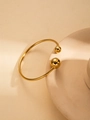 Detail of minimalist gold open bangle featuring polished spheres on a beige stand - Gold Open Double Ball Style