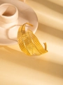 Detail shot of golden double feather bangle with fine texture on warm beige background - Overlapping Feather Leaf Style