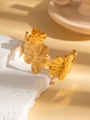 Macro view of gold floral open bangle with brushed texture on white stone base - Five-petal Brushed Flower Style