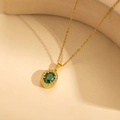 Luxuriöse goldene Titan-Halskette mit grünem ovalem Edelstein und Zirkonia-Rand - Grüne Halskette / Grün
