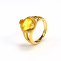 Detailed macro view of an 18k gold plated ring with a large faceted yellow gemstone - Gold Yellow Zirconia