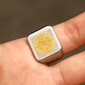 Macro detail of men's matte stainless steel signet ring with gold compass emblem - US 7 / Gold & Silver